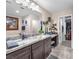 Spacious bathroom featuring a double sink vanity, granite countertops, and access to a walk-in closet at 2005 Via Firenze, Henderson, NV 89044