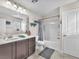 Bathroom with a single sink vanity, framed mirror, and a shower-tub combination at 2005 Via Firenze, Henderson, NV 89044