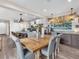 Open concept dining area next to a modern kitchen, with a beautiful wood table and upholstered chairs at 2005 Via Firenze, Henderson, NV 89044