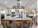 Bright, open kitchen featuring an island with granite countertops and modern industrial style lighting at 2005 Via Firenze, Henderson, NV 89044