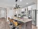 Well-lit kitchen with a central island, stainless steel appliances, and white cabinetry with glass doors at 2005 Via Firenze, Henderson, NV 89044