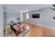 Living room with light gray walls, wood flooring, a mounted TV, and a white front door at 2029 Rose Coral Ave, Las Vegas, NV 89106