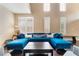 Bright and airy living room featuring a modern blue sofa and a large window at 2057 Wandering Doe Ln, Las Vegas, NV 89134