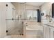 Luxurious bathroom featuring a walk-in shower, soaking tub, tile accents, and a serene ambiance at 2057 Wandering Doe Ln, Las Vegas, NV 89134