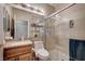 Updated bathroom with granite counters, wood cabinet, framed mirror, glass shower and built in shelf at 2516 Evansville Ave, Henderson, NV 89052