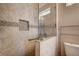 Bright bathroom featuring a tiled shower with glass door and a convenient grab bar for accessibility at 2516 Evansville Ave, Henderson, NV 89052