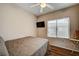 Well-lit bedroom features a window with blinds, a ceiling fan, and a wall-mounted television at 2516 Evansville Ave, Henderson, NV 89052