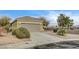 Well-maintained single-story home showcasing a two-car garage, mature trees, and desert landscaping at 2516 Evansville Ave, Henderson, NV 89052