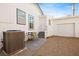 Rear of home with tidy gravel yard, AC unit, chairs, and painted steps at 274 Aztec Ln, Henderson, NV 89015
