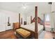 Spacious bedroom featuring a four-poster bed, wood floors, natural light, and vaulted ceilings at 274 Aztec Ln, Henderson, NV 89015