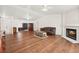 Large living room featuring a fireplace, hardwood floors, and seamless flow to kitchen and front door at 274 Aztec Ln, Henderson, NV 89015