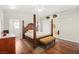 Comfortable bedroom featuring a four-poster bed, hardwood floors, and a ceiling fan at 274 Aztec Ln, Henderson, NV 89015
