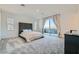This bedroom features plush carpet, a tufted headboard, and sliding glass doors to a balcony at 290 Mount Tyndall St, Henderson, NV 89015