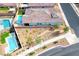 Aerial view of a single Gathering home and landscape, including a pool, a hot tub and desert landscaping at 314 Meadow Brush Pl, Henderson, NV 89011