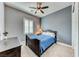 Bedroom with gray walls, shutters, ceiling fan and a bed with a blue coverlet at 314 Meadow Brush Pl, Henderson, NV 89011