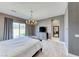 Spacious main bedroom with sliding glass doors, stylish light fixture, and neutral color palette at 314 Meadow Brush Pl, Henderson, NV 89011