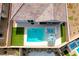 Aerial view of a backyard pool with a jacuzzi, surrounded by artificial grass and an umbrella at 314 Meadow Brush Pl, Henderson, NV 89011