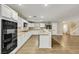 Modern kitchen with stainless steel appliances, a large island with bar seating, and a view into the dining and living area at 3189 Sisley Garden Ave, Henderson, NV 89044
