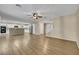 Open-concept living room boasts wood floors, a ceiling fan, and seamless flow into the adjacent kitchen and stairway at 3189 Sisley Garden Ave, Henderson, NV 89044
