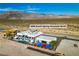Aerial view of the property showcasing the house, pool, sport court, and surrounding landscape at 3266 S Spring Mountain Blvd, Pahrump, NV 89048