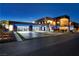 Modern home featuring a large garage, blue lighting, and sleek landscaping at 3266 S Spring Mountain Blvd, Pahrump, NV 89048