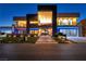 Striking contemporary home showcasing modern design, landscape lighting, and a unique car display feature at 3266 S Spring Mountain Blvd, Pahrump, NV 89048
