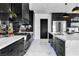 Contemporary kitchen featuring glossy black cabinets, a mirrored backsplash, and a large island with white countertops at 3266 S Spring Mountain Blvd, Pahrump, NV 89048
