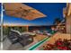 Stunning twilight view of the pool with water features, lounge chairs, and desert views at 3266 S Spring Mountain Blvd, Pahrump, NV 89048