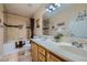 The bathroom has double sinks, a soaking tub, and brown tile at 3831 Flickering Star Dr, Las Vegas, NV 89103