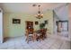Cozy dining room featuring tile flooring, a classic chandelier, and plenty of natural light at 3831 Flickering Star Dr, Las Vegas, NV 89103