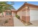 Welcoming home with desert landscaping, a two-car garage, and a front entrance featuring decorative stonework at 3831 Flickering Star Dr, Las Vegas, NV 89103