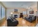 Comfortable living room with hardwood floors, a fireplace, and bright windows with shutter-style blinds at 3831 Flickering Star Dr, Las Vegas, NV 89103