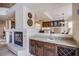 View of wet bar with granite counters, wine rack and fireplace adjacent to the dining area at 4372 Melrose Abbey Pl, Las Vegas, NV 89141