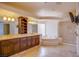 A luxurious bathroom with a double vanity, shelving unit, jetted tub, glass block window and shower stall at 4372 Melrose Abbey Pl, Las Vegas, NV 89141