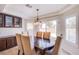 Dining area featuring dark wood table, six chairs, plantation shutters and glass door to the backyard at 4372 Melrose Abbey Pl, Las Vegas, NV 89141