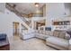 Spacious living room with fireplace, tile flooring, grand staircase, and open floor plan to the kitchen at 4372 Melrose Abbey Pl, Las Vegas, NV 89141