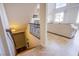 Stairway leading to a living room with tile flooring, large windows, and an oversized sofa with neutral tones at 4372 Melrose Abbey Pl, Las Vegas, NV 89141