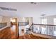Upstairs loft featuring wood floors, decorative metal railings, and view of the downstairs living areas at 4372 Melrose Abbey Pl, Las Vegas, NV 89141