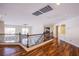 Bright loft area featuring hardwood floors, decorative railing, and an arched doorway leading to another room at 4372 Melrose Abbey Pl, Las Vegas, NV 89141