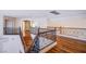 Upstairs loft showcasing hardwood floors, metal railings, and view of the downstairs living area at 4372 Melrose Abbey Pl, Las Vegas, NV 89141