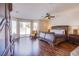Spacious main bedroom featuring dark wood floors, a ceiling fan, and sliding glass doors to the backyard at 4372 Melrose Abbey Pl, Las Vegas, NV 89141