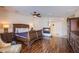 An expansive main bedroom with wood floors, ceiling fan, fireplace, and access to a private bath and closet at 4372 Melrose Abbey Pl, Las Vegas, NV 89141