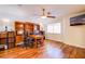 A well-lit home office includes a hardwood floor, ceiling fan, built-in shelves, and large window for natural light at 4372 Melrose Abbey Pl, Las Vegas, NV 89141