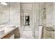 Modern bathroom with marble tile, double sinks, and a glass-enclosed shower with contemporary fixtures at 4381 W Flamingo Rd # 3002, Las Vegas, NV 89103