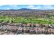 Expansive aerial view of a community with a lush green golf course and beautiful mountain views in the background at 508 Via Palermo Dr, Henderson, NV 89011