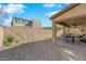 An exterior view of the backyard shows a covered patio and low maintenance desert landscaping at 508 Via Palermo Dr, Henderson, NV 89011