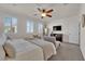 Light filled bedroom with a ceiling fan, shutters, and a large bed with soft linens at 508 Via Palermo Dr, Henderson, NV 89011