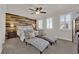 Spacious bedroom with a wood accent wall, ceiling fan, and light gray chaise lounges at 508 Via Palermo Dr, Henderson, NV 89011