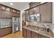 Gourmet kitchen with stainless steel appliances, granite countertops, designer backsplash and dark wood cabinetry at 508 Via Palermo Dr, Henderson, NV 89011