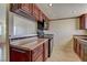 Well-lit kitchen features sleek, modern, black appliances and dark wood cabinetry with a stone countertop at 5345 Silvermist Ct # 203, Las Vegas, NV 89122
